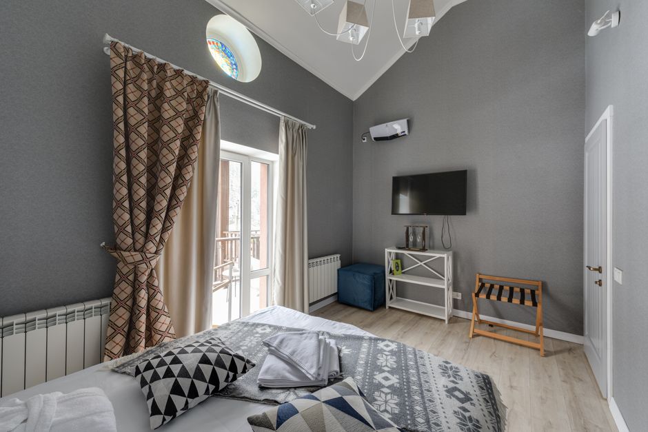 A modern bedroom featuring cozy decor, geometric patterns, and natural light.