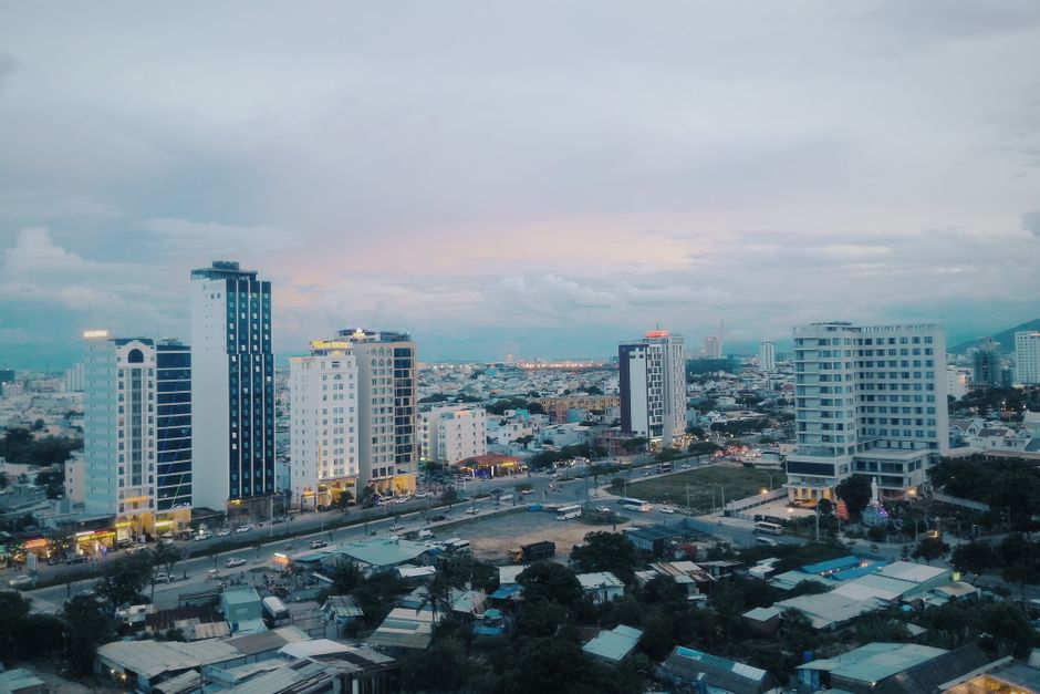 Stunning aerial view of a modern urban skyline with skyscrapers at dusk, capturing city lights and architecture.