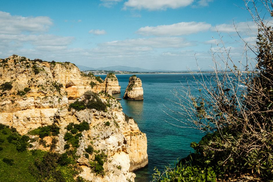 Scenic view of rocky cliffs overlooking the ocean under a clear blue sky.