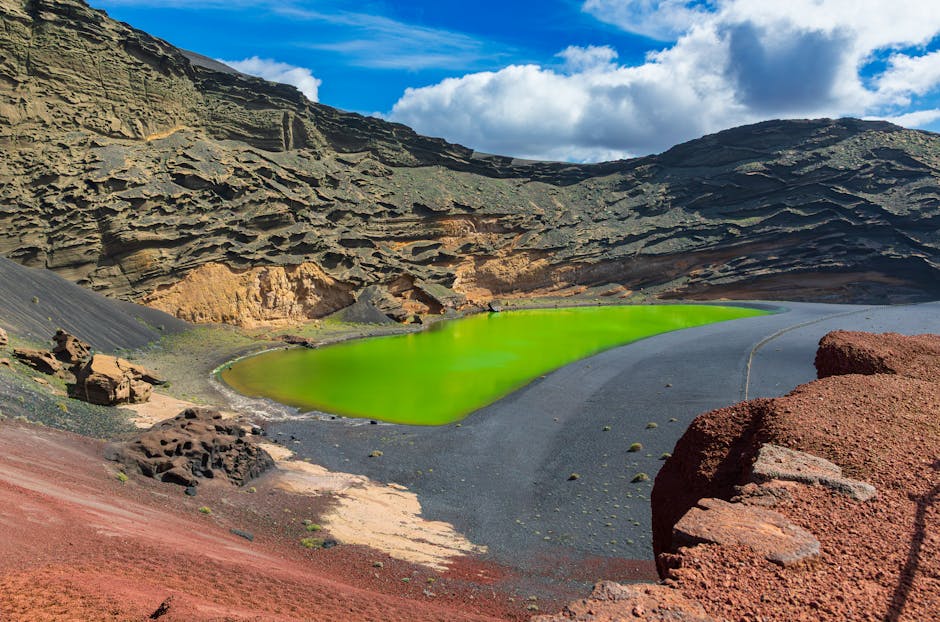 Bright green lagoon nestled in El Golfo volcanic crater in Lanzarote, Spain.