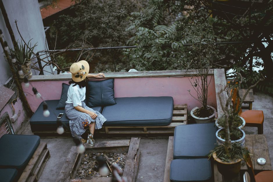 Woman relaxing on an outdoor terrace with greenery in Hanoi, Vietnam.