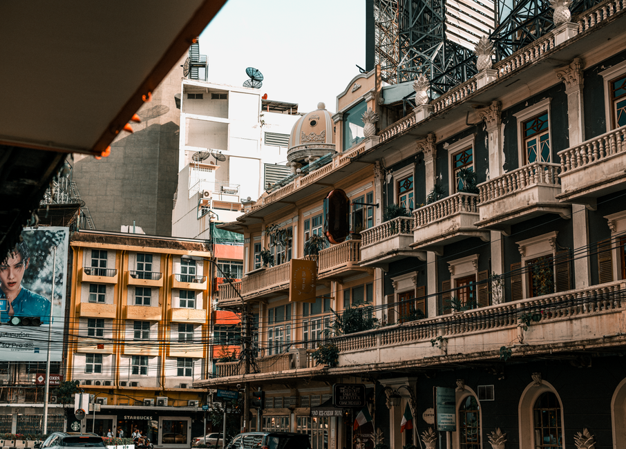 Charming street view in Bangkok showcasing historic architecture and urban life.