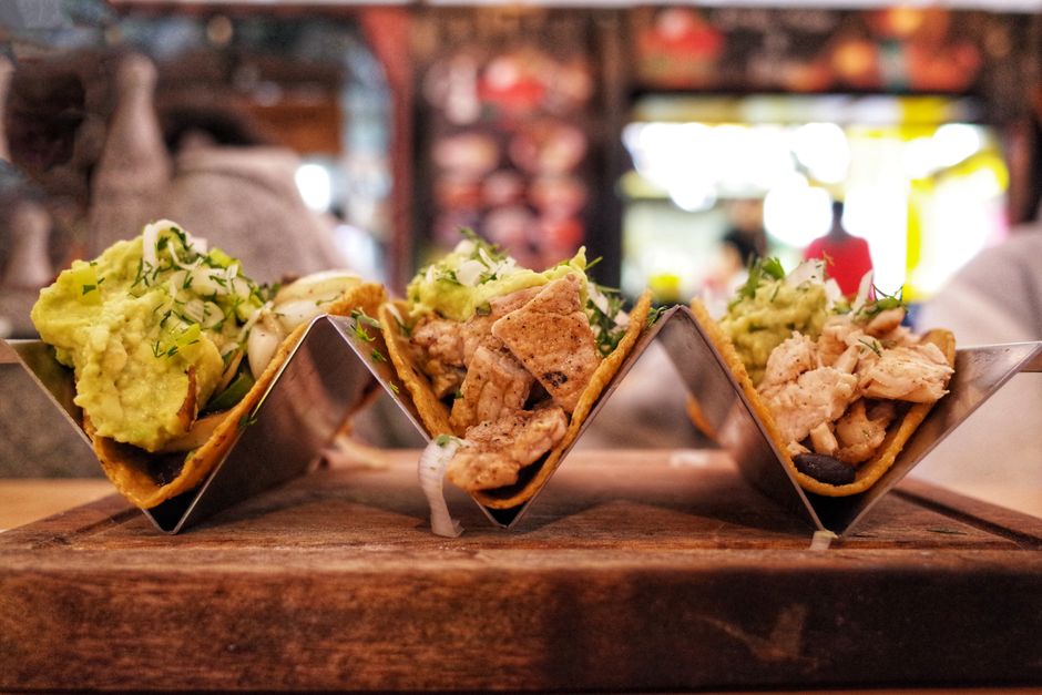 Close-up of delicious chicken tacos with avocado, served in a modern restaurant setting.