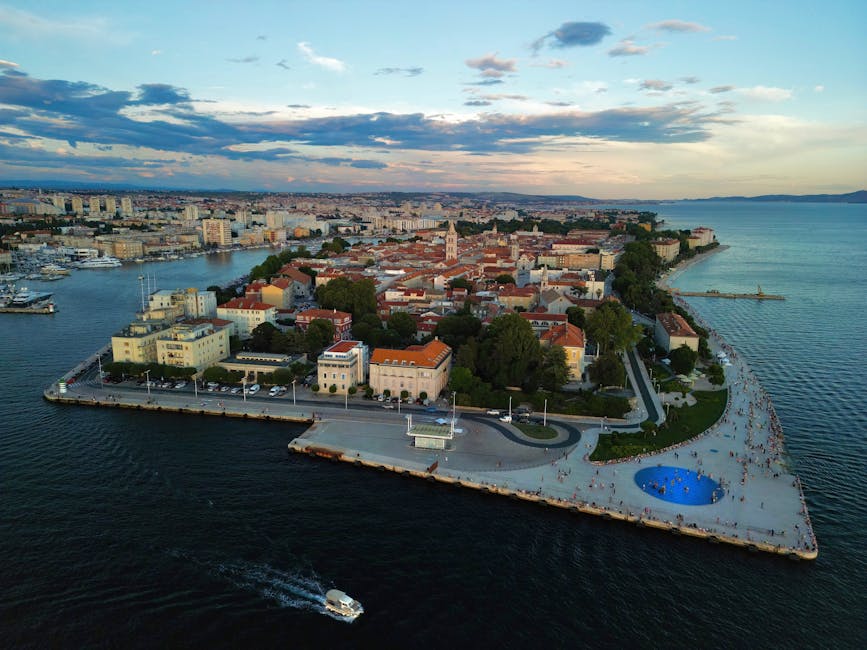 Scenic aerial view of Zadar's peninsula and harbor during sunset with vibrant cityscape and the Adriatic Sea.