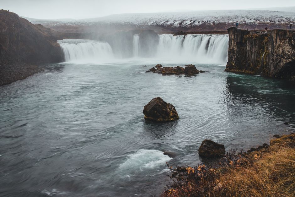 Capture the breathtaking view of Godafoss waterfall surrounded by Iceland's serene winter landscape.
