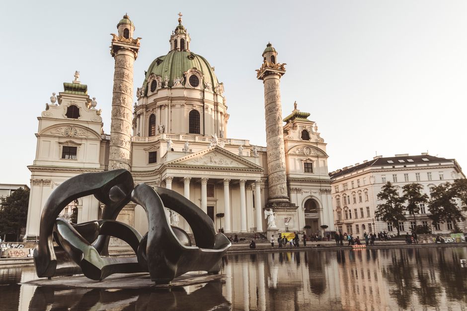 Beautiful architecture of St. Charles Church with reflective pond in Vienna.