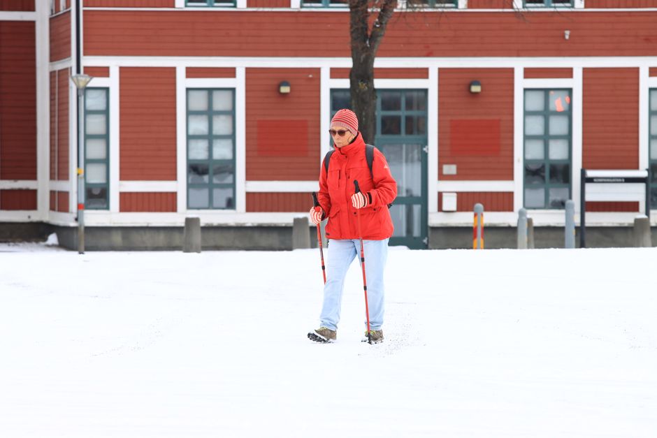 Woman walking with Nordic poles in snowy Jönköping, Sweden, winter time