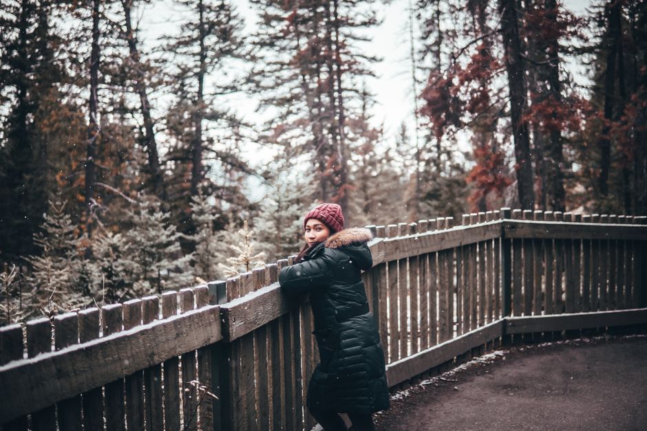 Woman in a warm coat enjoys a scenic autumn walk in Jasper National Park, Alberta.