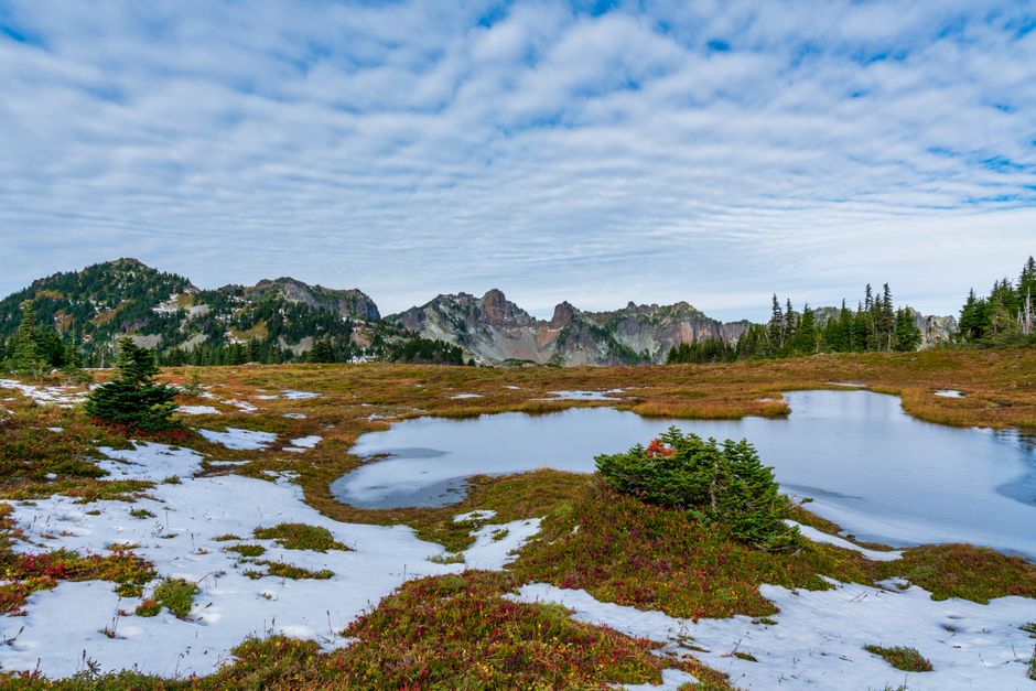 Beautiful alpine landscape with snow, water, and mountains in Washington's Mount Rainier National Park.