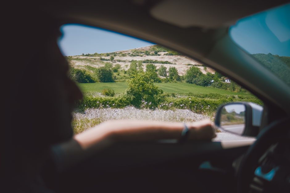 Relaxing drive with scenic countryside views through a car window on a sunny day.