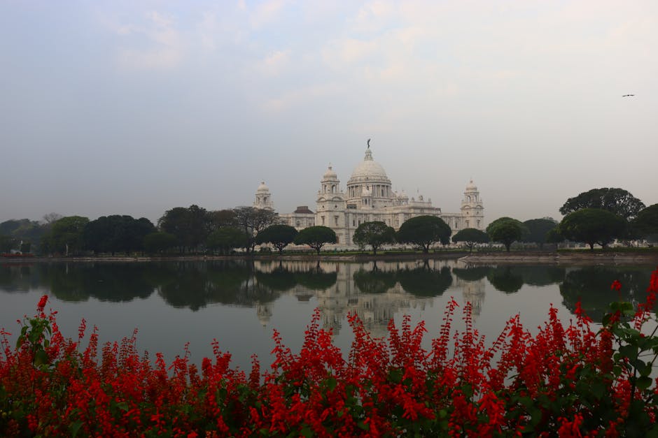 Stunning view of Victoria Memorial in Kolkata with vibrant red flowers in the foreground.